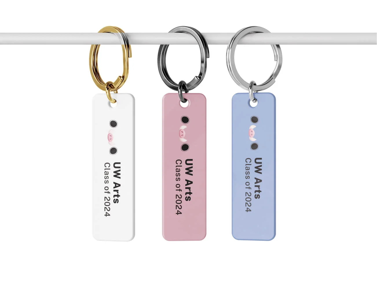 Three UW Arts class of 2024 keychains, in white, pink and blue